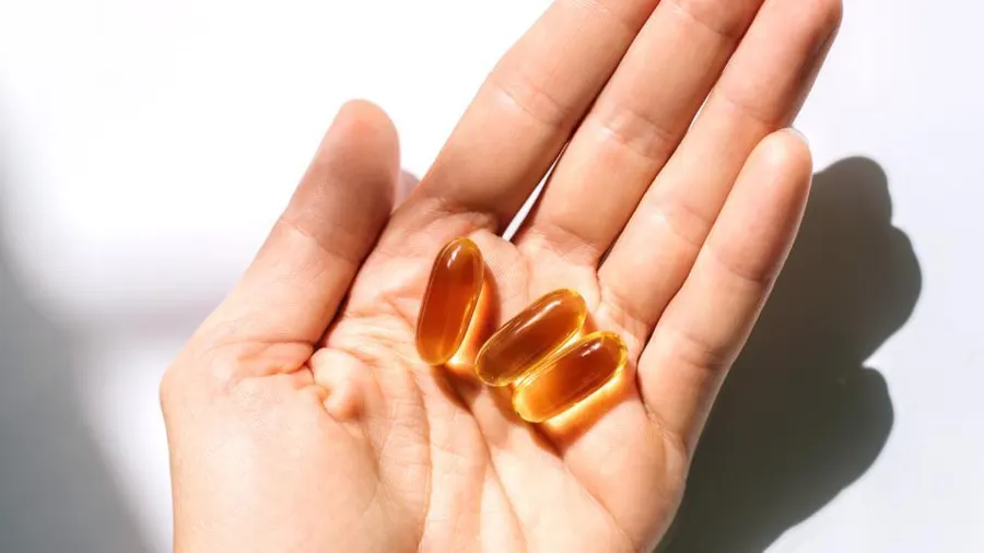 A person with omega 3 capsules in his hand | omega 3 capsules | exclusiveblogspot.com